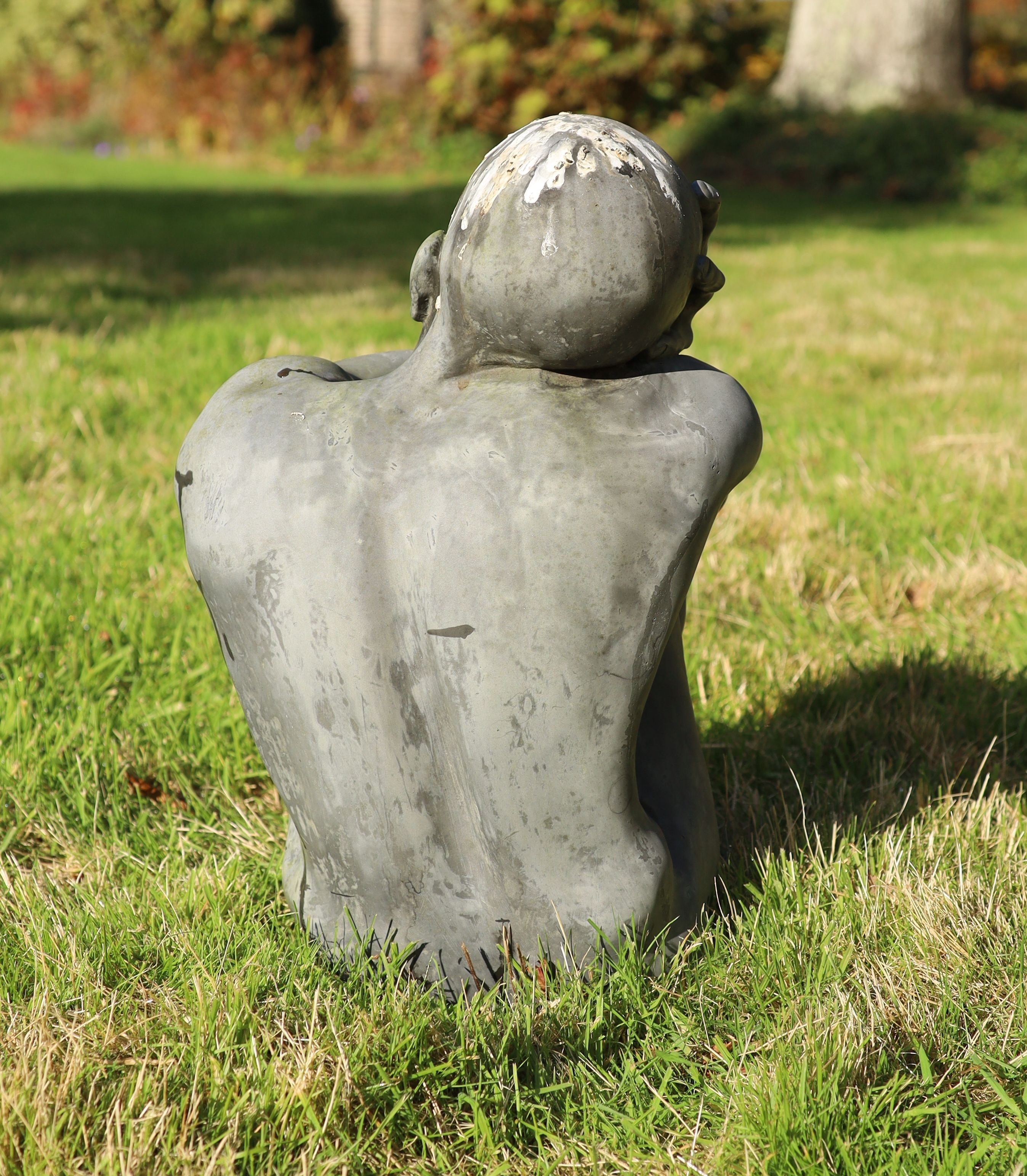 A simulated lead resin garden statue of a seated man, height 49cm, with a damaged marble pedestal, height 78cm